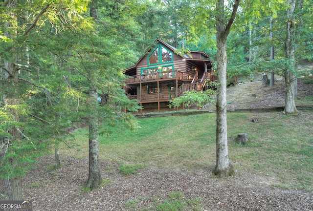 rear view of house with a deck and a yard