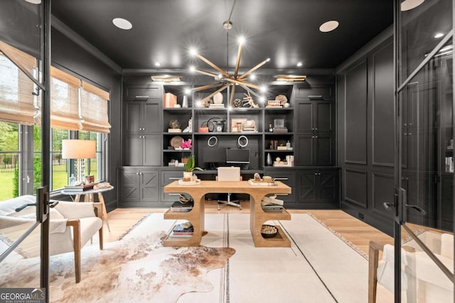 home office featuring light hardwood / wood-style flooring and a notable chandelier