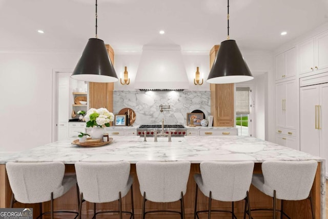 kitchen featuring white cabinets, backsplash, a spacious island, and custom exhaust hood