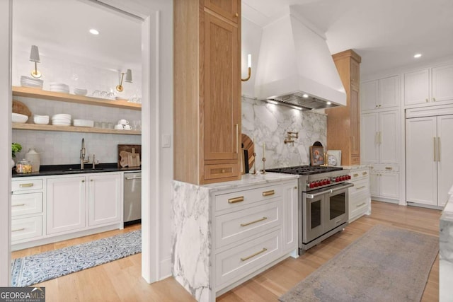 kitchen featuring decorative backsplash, high end appliances, white cabinetry, and custom exhaust hood