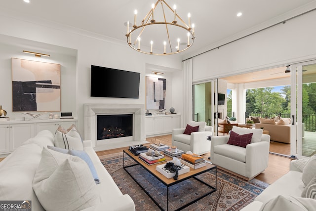 living room featuring crown molding, light hardwood / wood-style floors, and a chandelier