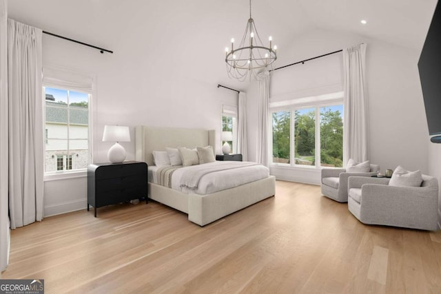 bedroom with vaulted ceiling, a chandelier, light hardwood / wood-style floors, and multiple windows