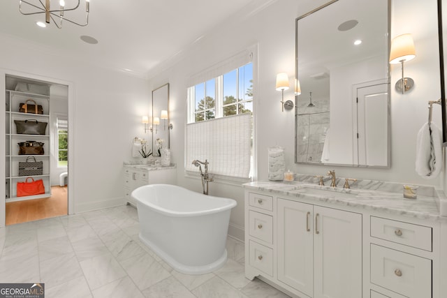 bathroom featuring a bathtub, vanity, ornamental molding, hardwood / wood-style floors, and a notable chandelier