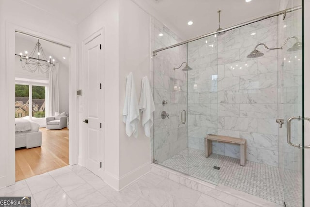 bathroom featuring a notable chandelier, wood-type flooring, and a shower with shower door