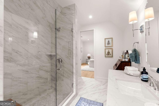 bathroom with lofted ceiling, a shower with door, and vanity