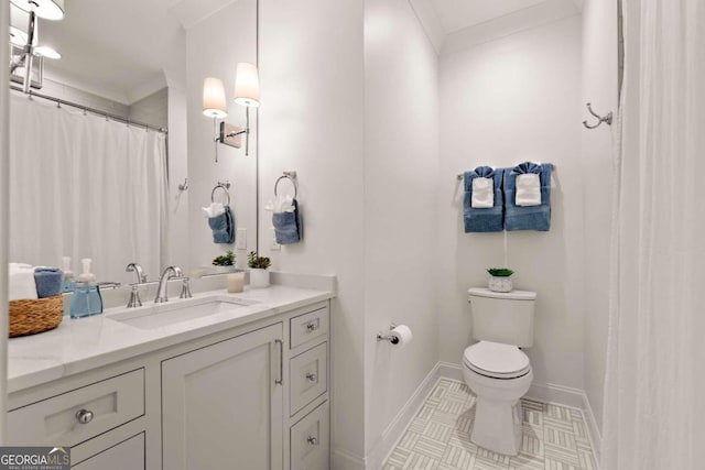 bathroom featuring ornamental molding, vanity, and toilet