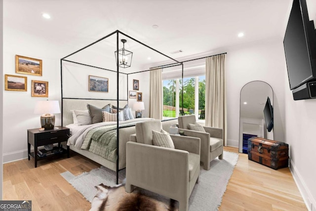 bedroom with a chandelier and light hardwood / wood-style floors