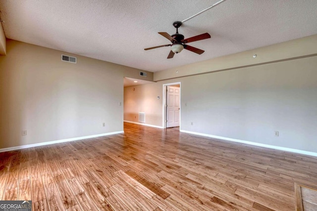 unfurnished room featuring a textured ceiling, light wood-type flooring, and ceiling fan