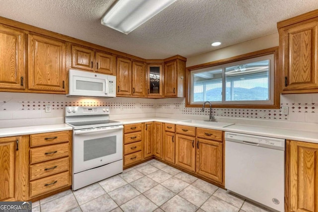 kitchen featuring white appliances, sink, light tile patterned floors, and tasteful backsplash