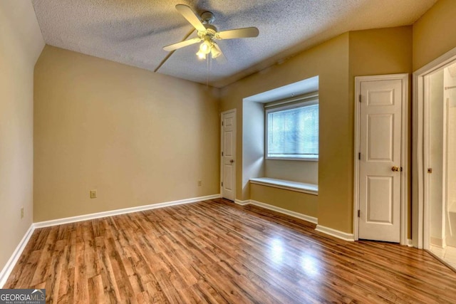 unfurnished bedroom featuring a textured ceiling, ceiling fan, and light hardwood / wood-style flooring