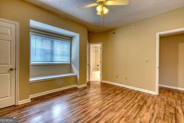 interior space with a textured ceiling, ceiling fan, and light hardwood / wood-style flooring