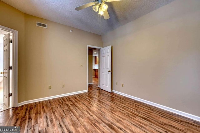 spare room featuring ceiling fan, a textured ceiling, and light wood-type flooring