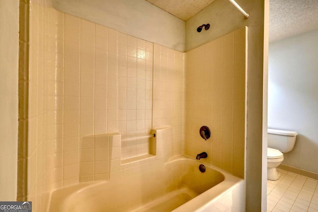 bathroom featuring a textured ceiling, toilet, tile patterned floors, and tiled shower / bath