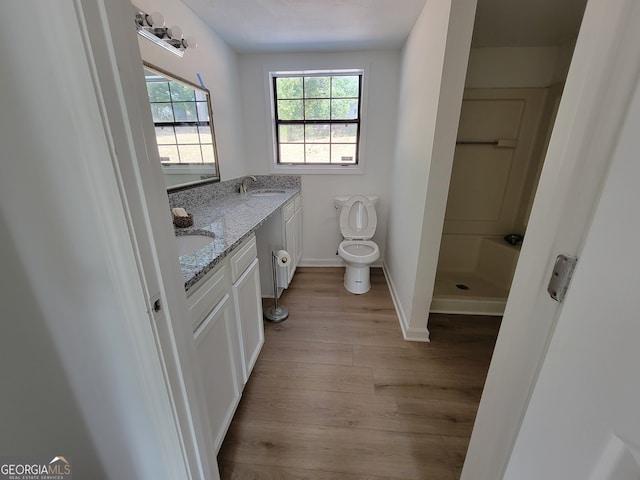 bathroom with vanity, a shower, hardwood / wood-style floors, and toilet