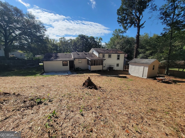 back of property with a storage unit and a patio