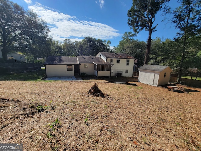 back of property with a yard, a storage unit, and a patio area