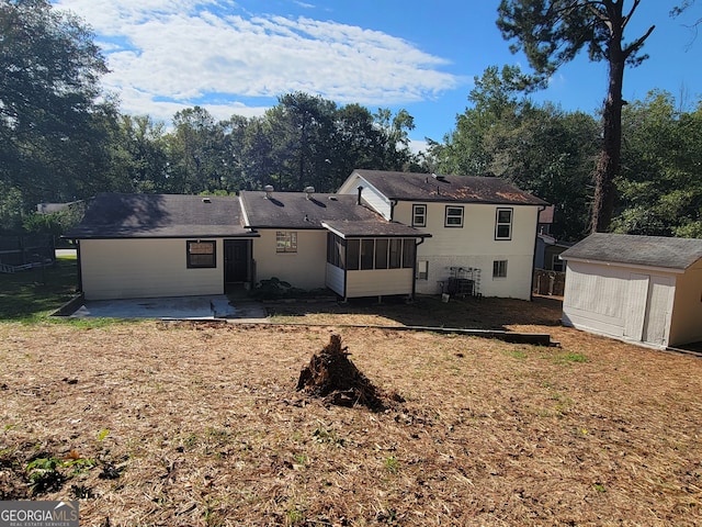 back of property with a storage unit, a sunroom, and a patio area