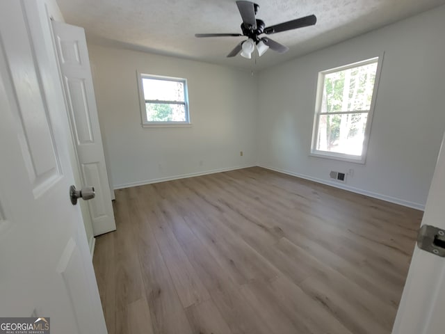 interior space with light hardwood / wood-style flooring, ceiling fan, and a textured ceiling