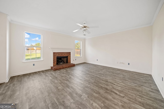 unfurnished living room featuring dark wood-type flooring, ornamental molding, and plenty of natural light