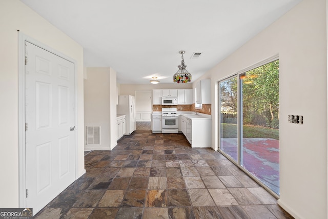 kitchen with white cabinets, white appliances, hanging light fixtures, and sink