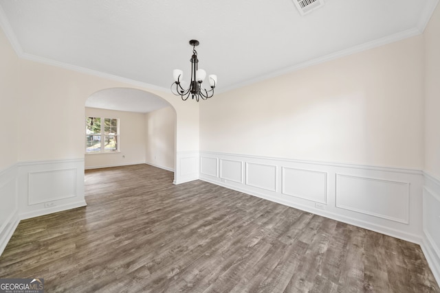 spare room featuring crown molding, dark hardwood / wood-style flooring, and a notable chandelier