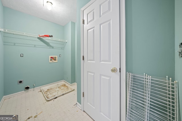 washroom with hookup for an electric dryer, a textured ceiling, hookup for a washing machine, and hookup for a gas dryer