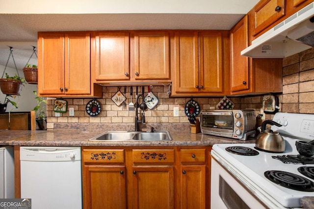 kitchen with decorative backsplash, white appliances, a textured ceiling, dark stone counters, and sink