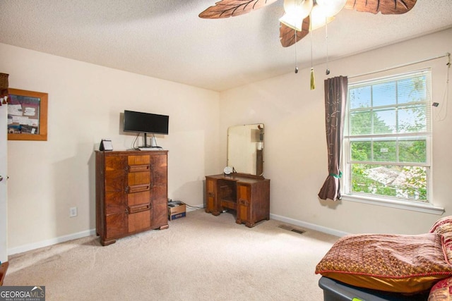 bedroom featuring ceiling fan, a textured ceiling, and light carpet