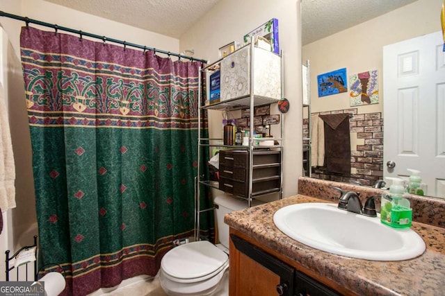 bathroom with a textured ceiling, vanity, and toilet