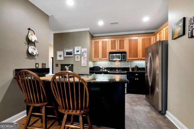 kitchen featuring tile patterned flooring, a breakfast bar area, kitchen peninsula, stainless steel appliances, and ornamental molding