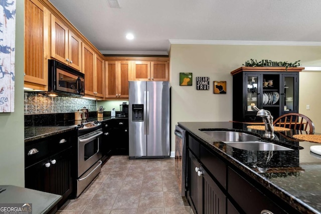 kitchen with dark stone counters, sink, backsplash, appliances with stainless steel finishes, and ornamental molding