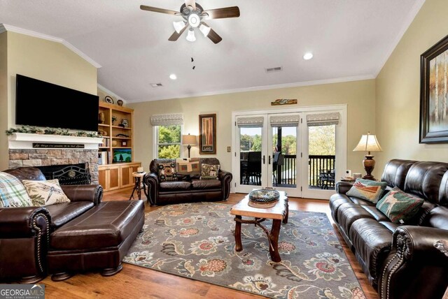 living room with wood-type flooring, lofted ceiling, crown molding, and ceiling fan