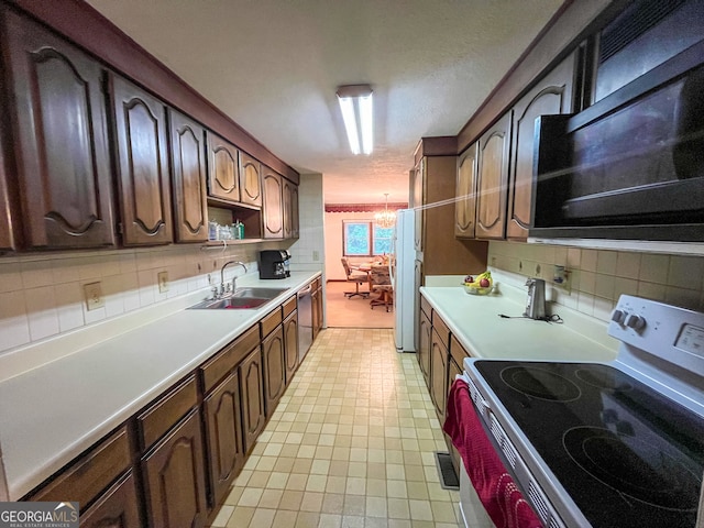 kitchen featuring a chandelier, sink, decorative backsplash, appliances with stainless steel finishes, and dark brown cabinetry