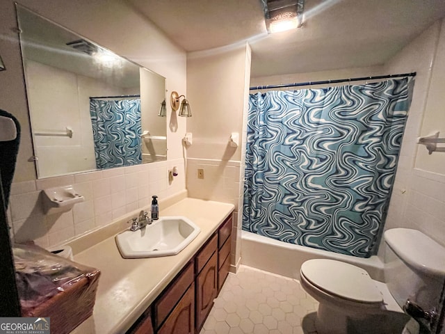 full bathroom with vanity, toilet, shower / bathtub combination with curtain, tile walls, and tile patterned flooring