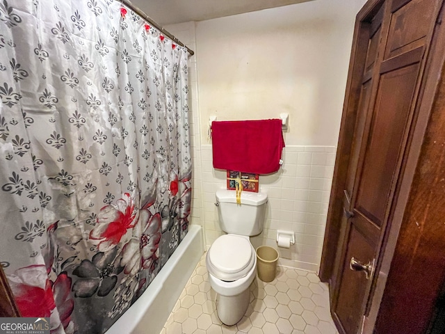 bathroom featuring tile walls, toilet, tile patterned floors, and shower / bath combination with curtain