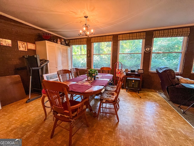 dining space featuring a textured ceiling, crown molding, and an inviting chandelier