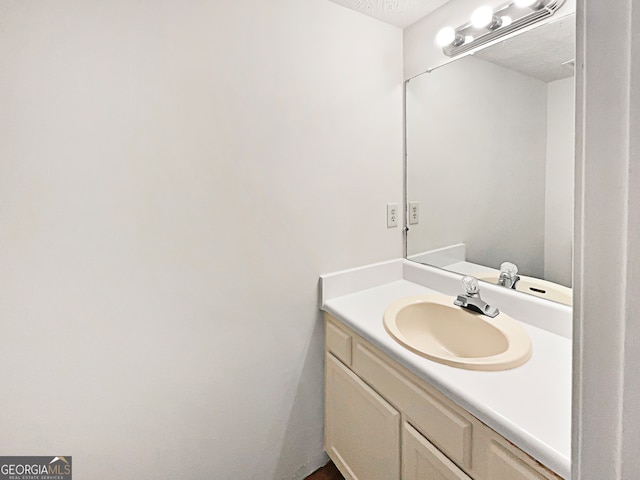 bathroom featuring a textured ceiling and vanity