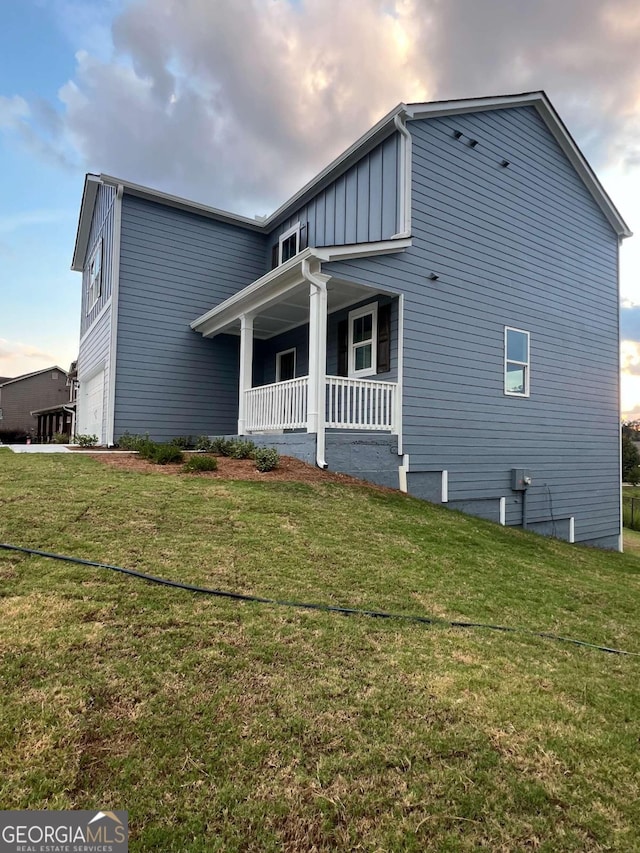 rear view of property with a porch and a lawn