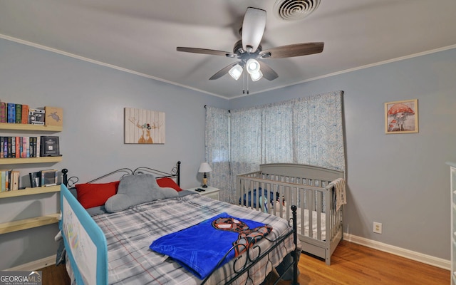 bedroom featuring wood-type flooring, ornamental molding, and ceiling fan