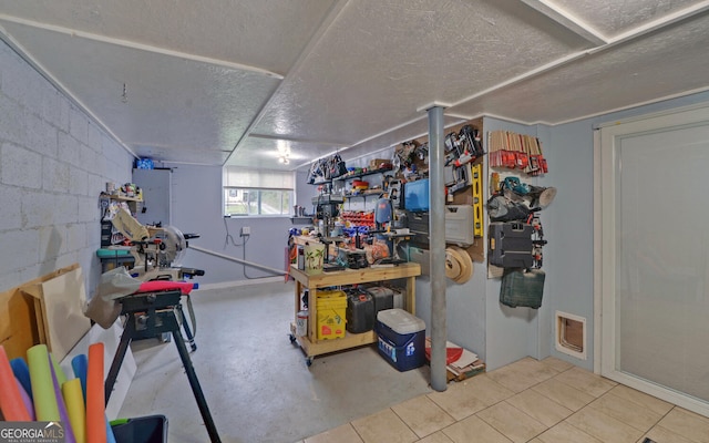 basement with a textured ceiling and tile patterned floors