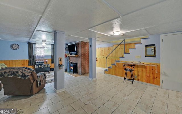 basement featuring wood walls and a textured ceiling