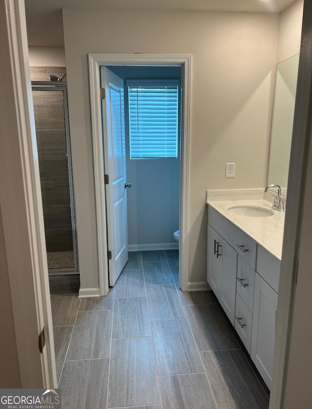 bathroom featuring vanity, toilet, and an enclosed shower