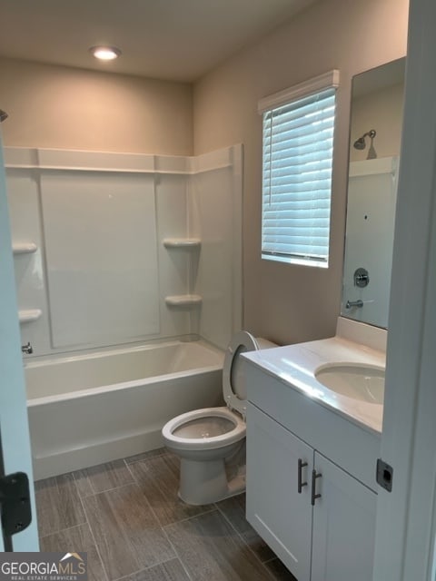 full bathroom with washtub / shower combination, vanity, and toilet