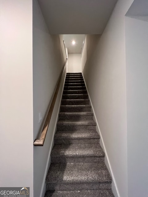 stairway featuring carpet