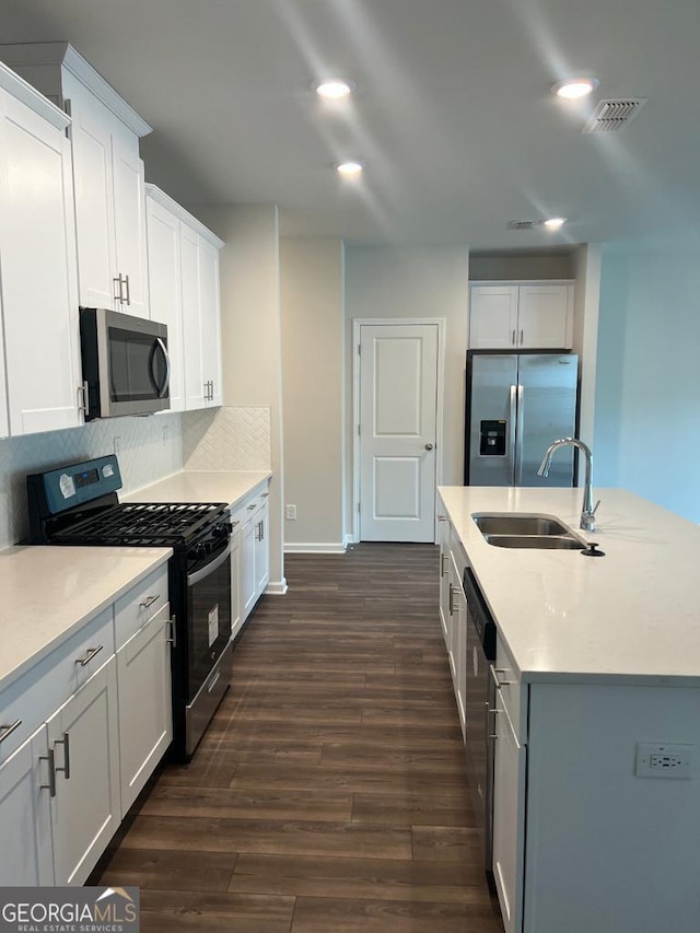 kitchen with white cabinetry, appliances with stainless steel finishes, sink, and dark hardwood / wood-style flooring