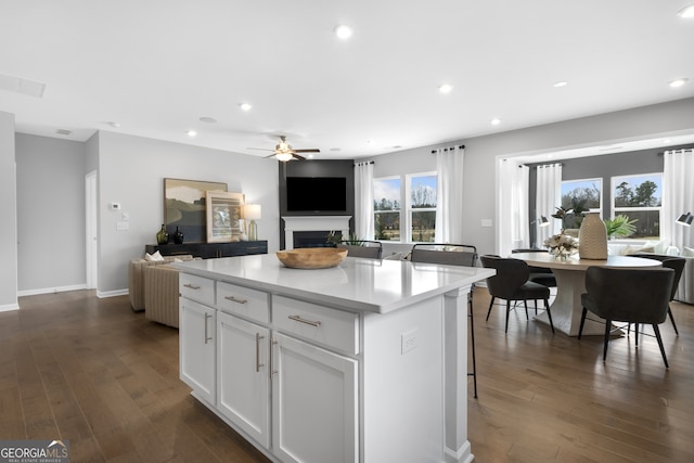 kitchen featuring ceiling fan, dark hardwood / wood-style floors, white cabinetry, and a kitchen island