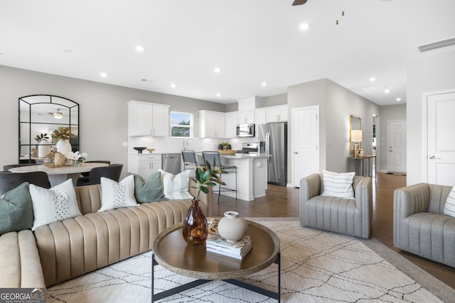 living room featuring ceiling fan and light hardwood / wood-style floors