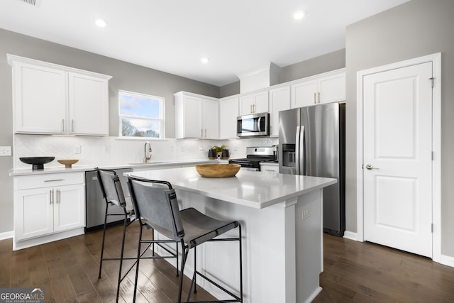 kitchen featuring dark wood-type flooring, white cabinets, and appliances with stainless steel finishes