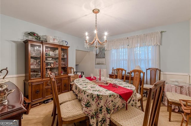 carpeted dining space featuring a notable chandelier