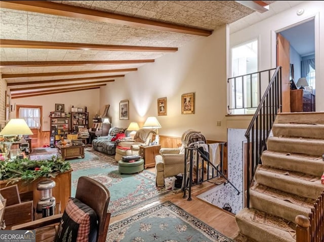 living room with beam ceiling, hardwood / wood-style floors, and plenty of natural light